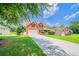 Well-manicured front yard with a spacious driveway leading up to a lovely brick two-story home at 3961 S River Ln, Ellenwood, GA 30294