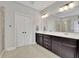 A bathroom includes double sinks, modern lighting, tile floors, and shower at 2740 Longacre Park Way, Lawrenceville, GA 30044