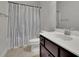 Cozy bathroom featuring a shower with striped curtain and a white sink with dark cabinets at 2740 Longacre Park Way, Lawrenceville, GA 30044