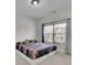 Comfortable bedroom featuring a window with blinds and decorative pillows on the bed at 2740 Longacre Park Way, Lawrenceville, GA 30044
