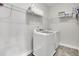 Clean laundry room with white washer and dryer, shelving, and tiled flooring at 2740 Longacre Park Way, Lawrenceville, GA 30044