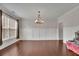 Elegant living room features hardwood floors, wainscoting, ample natural light, and a stylish chandelier at 2740 Longacre Park Way, Lawrenceville, GA 30044