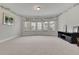 Spacious living room with large windows, neutral carpet, and decorative vines along the ceiling at 2740 Longacre Park Way, Lawrenceville, GA 30044