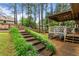 Multi-level backyard with stone steps, patio area, and lush landscaping at 490 Hunters Glen Ct, Lawrenceville, GA 30044