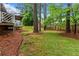 Spacious backyard featuring mature trees, a covered porch and a well-maintained lawn at 490 Hunters Glen Ct, Lawrenceville, GA 30044