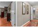 Hallway with hardwood floors, mirrors, and doorway with stairs leading to another room at 490 Hunters Glen Ct, Lawrenceville, GA 30044