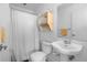 Clean bathroom featuring a toilet, sink, shower with white curtains, and well-lit interiors at 1346 Peter Haughton Nw Way # 2, Atlanta, GA 30318