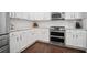 Modern kitchen with stainless steel appliances, white cabinets, subway tile backsplash, and hardwood flooring at 207 Harmony Lake Dr, Canton, GA 30115