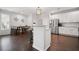 Open kitchen view with stainless appliances, granite counters, an island with seating, and a dining table at 207 Harmony Lake Dr, Canton, GA 30115