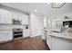 Modern kitchen with stainless steel appliances, white cabinets, and granite countertops at 207 Harmony Lake Dr, Canton, GA 30115