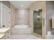 A luxurious bathroom features stone tilework, a soaking tub, and a glass enclosed shower at 1 Brookhaven Ne Dr # 205, Atlanta, GA 30319