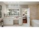A bright bathroom features double sinks, white cabinetry, and access to the bedroom at 1 Brookhaven Ne Dr # 205, Atlanta, GA 30319
