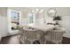 This dining area offers natural light, wainscoting, and a white table with stylish seating at 1620 Brook Ivy Dr, Lawrenceville, GA 30044