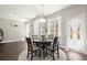 Bright dining area with round table, modern light fixture, and view to the backyard through sheer-curtained windows at 1620 Brook Ivy Dr, Lawrenceville, GA 30044
