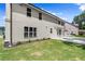Side view of a two-story home with a well-maintained lawn and concrete patio area at 1620 Brook Ivy Dr, Lawrenceville, GA 30044