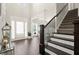 Bright foyer boasts hardwood floors, staircase with dark wood handrail, and an open floor plan at 1620 Brook Ivy Dr, Lawrenceville, GA 30044