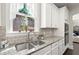Close-up view of the kitchen sink area with stainless steel sink, tile backsplash and granite counters at 1620 Brook Ivy Dr, Lawrenceville, GA 30044