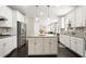 Well-lit kitchen boasts white cabinets, stainless steel appliances, and an island with seating at 1620 Brook Ivy Dr, Lawrenceville, GA 30044
