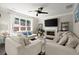 Bright living room featuring comfortable sofas, a fireplace, and a modern ceiling fan at 1620 Brook Ivy Dr, Lawrenceville, GA 30044