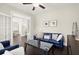 Comfortable living room features a blue couch, dark wood floors, decor, and access to dining area at 1620 Brook Ivy Dr, Lawrenceville, GA 30044