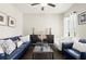 The living room features a blue couch and chair, glass coffee table, and modern console at 1620 Brook Ivy Dr, Lawrenceville, GA 30044
