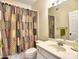 Bathroom featuring a unique shower curtain, white cabinets, sink and mirror at 4221 Bretdale Nw Run, Kennesaw, GA 30152