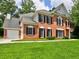 Charming brick two-story home featuring black shutters, well-manicured landscaping, and an attached garage at 4221 Bretdale Nw Run, Kennesaw, GA 30152