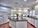 Bright eat-in kitchen with white cabinets, granite counters, a center island, and stainless steel appliances at 4221 Bretdale Nw Run, Kennesaw, GA 30152