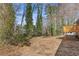 Large backyard with mature trees, offering privacy and shade next to the home's wooden deck at 5277 Cardinal Nw Ln, Lilburn, GA 30047