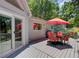Inviting back deck featuring an outdoor dining area, a grill, and views of the surrounding trees at 8531 Lake Dr, Snellville, GA 30039