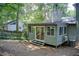 View of the backyard, with a grey sunroom including sliding glass doors and wood siding, with a wooded surround at 8531 Lake Dr, Snellville, GA 30039