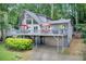 Gray home featuring a spacious wrap-around deck overlooking a lush, wooded lot at 8531 Lake Dr, Snellville, GA 30039