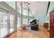 Open living area with lots of natural light and views of trees, with a piano and leather couch at 8531 Lake Dr, Snellville, GA 30039
