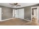 Bedroom with neutral carpet, ceiling fan, and ensuite bath access at 6980 Roswell Rd # N5, Atlanta, GA 30328