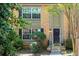 Charming brick townhome showcasing a black front door, complemented by neatly trimmed bushes and lush greenery at 6980 Roswell Rd # N5, Atlanta, GA 30328