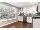 Bright kitchen with stainless steel appliances, granite counters, and a large window overlooking greenery at 6980 Roswell Rd # N5, Atlanta, GA 30328