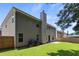 Spacious backyard with a large green lawn, wooden fence, and back of house at 802 Cormac Dr, Riverdale, GA 30296