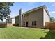 Well-maintained backyard with a large grassy area, wooden fence, and a patio at 802 Cormac Dr, Riverdale, GA 30296