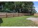 Large grassy backyard featuring a wood fence and mature trees at 802 Cormac Dr, Riverdale, GA 30296
