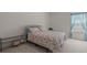 Cozy bedroom with floral print bedding, a window, and a metal shelf unit at 802 Cormac Dr, Riverdale, GA 30296