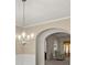 Open concept dining room with decorative chandelier and arched entry into an adjacent seating area at 802 Cormac Dr, Riverdale, GA 30296