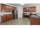 Well-lit kitchen featuring stainless appliances, wood cabinets, and plank flooring at 802 Cormac Dr, Riverdale, GA 30296