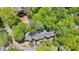 Aerial view of property highlighting rooflines nestled among trees with greenery and driveways at 171 Riverview Trl, Roswell, GA 30075