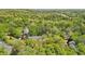An aerial view of the home, surrounded by a lush landscape of mature trees, providing a secluded feel at 171 Riverview Trl, Roswell, GA 30075