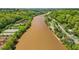 An aerial view of a meandering river flanked by a horse farm and small buildings with docks along the bank at 171 Riverview Trl, Roswell, GA 30075