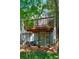A private townhouse backyard with seating beneath a deck, surrounded by trees and landscaping at 171 Riverview Trl, Roswell, GA 30075
