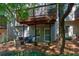 Townhouse backyard features seating area with a balcony above and mature trees offering shade at 171 Riverview Trl, Roswell, GA 30075