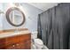 Bathroom featuring a vanity with solid countertops, a round mirror, and a shower with dark curtains at 171 Riverview Trl, Roswell, GA 30075