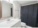 Bathroom with a white vanity and a shower with dark curtains next to the toilet at 171 Riverview Trl, Roswell, GA 30075