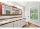 Bright bathroom with double sinks, granite countertops, and a large framed mirror over the vanity at 171 Riverview Trl, Roswell, GA 30075